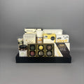 Luxury sweet and savoury gourmet gift basket with Castello Brie cheese, artisan jam, chocolate truffles, and premium snacks displayed on a black serving tray.