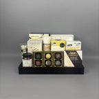 Luxury sweet and savoury gourmet gift basket with Castello Brie cheese, artisan jam, chocolate truffles, and premium snacks displayed on a black serving tray.