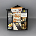 A curated gourmet food gift basket in a black magnet box, containing a Carr's water crackers, Laura Secord Butter & Cream Fudge, Chipotle Cheddar Popcorn, a box of Canadian Cheddar Biscuits, a box of Castello Brie cheese, a bag of pretzels, and mixed nuts.
