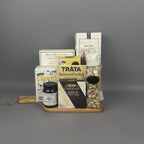 A gourmet gift hamper arranged on a small wooden tray. The hamper includes a jar of Provisions jam, Castello Brie Cheese, a box of Canadian Cheddar Biscuits, a Smoked Salmon Pocket, a box of Sea Salt Breadsticks, a box of crackers, and a dried salami stick.