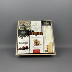 A gourmet chocolate and cookie gift box set in a light wood tray, featuring various branded packaged sweets including, J&M chocolate chip cookies, Laura Secord chocolate bar and butter and cream fudge, dark chocolate almonds, and chocolate covered raisins. 