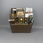A gourmet chocolate gift basket in a brown woven basket, filled with assorted chocolates, truffles, and chocolate bars from brands like Made and Sprucewood.
