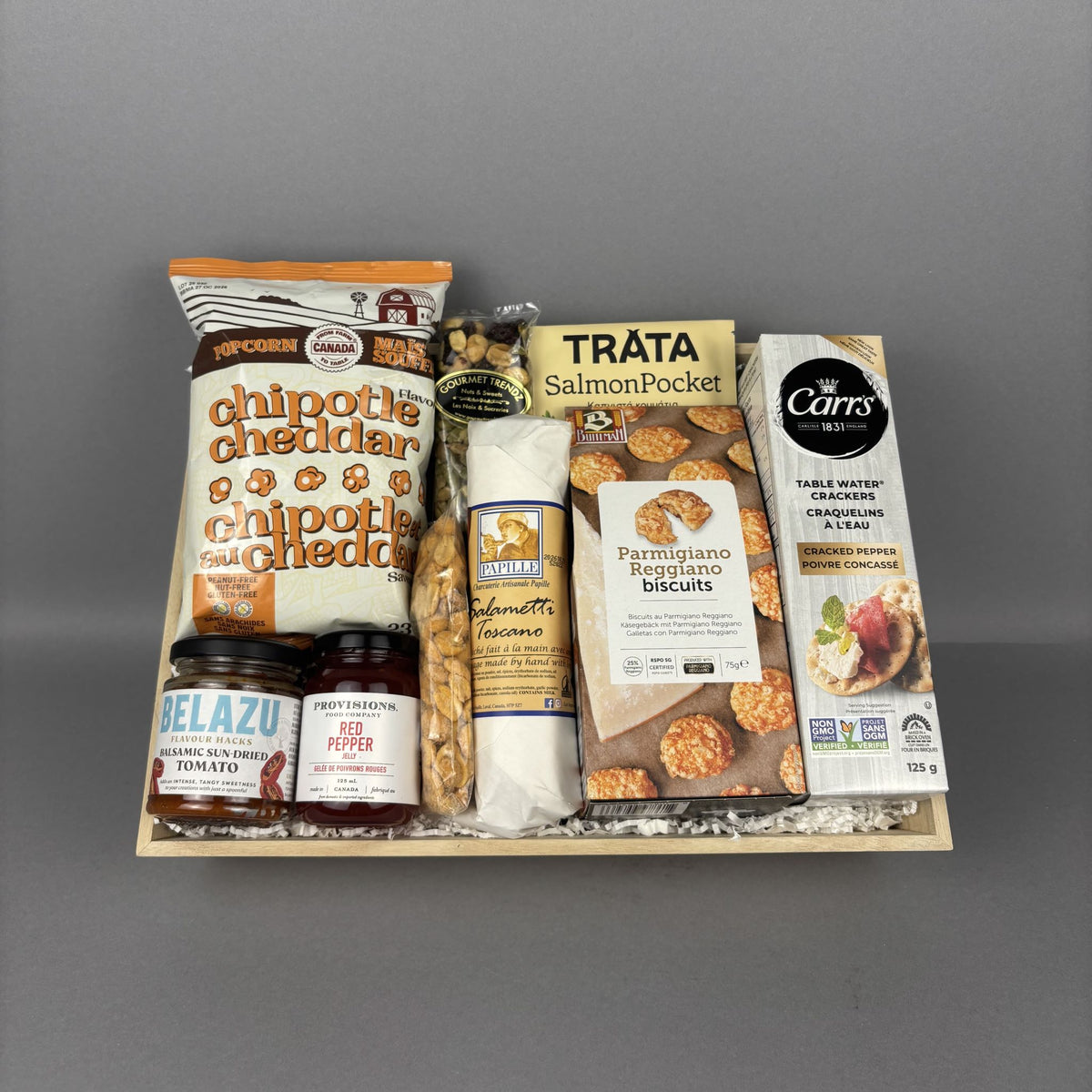 Gourmet gift crate in a wooden tray featuring smoked salmon, chipotle cheddar popcorn, artisan crackers, Provisions jam, savory spreads, premium snacks, and specialty foods